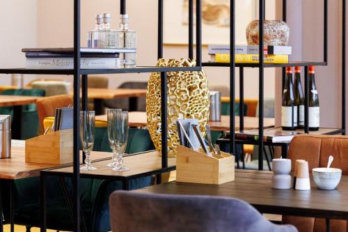 a table in a restaurant with a shelf with wine glasses at Hotel Anna Amalia in Weimar