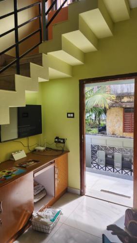 an office with a desk and a sliding glass door at Swan Village Villa in Nāgercoil