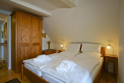 une chambre avec un lit blanc avec des serviettes dessus dans l'établissement Haus Gud Hööb Whg 08, à Wyk auf Föhr