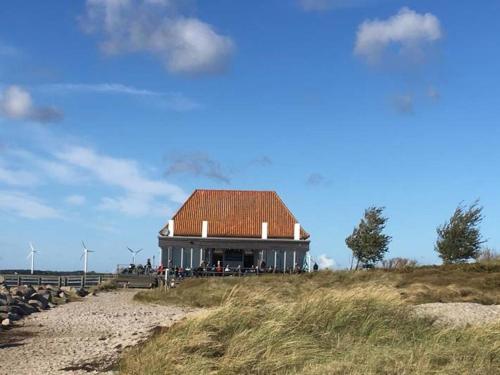 a building with a roof on top of a hill at Ferienwohnung Meeresblick "Fehmarn" in Fehmarn