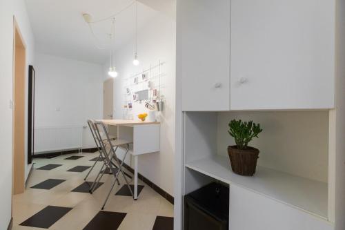 a kitchen with white cabinets and a table at Tara Garden in Velika Gorica