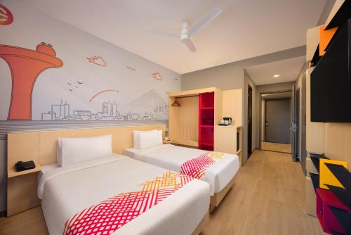 a bedroom with two beds and a tv at Ginger Nagpur City Centre in Nagpur