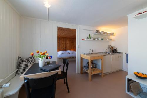 a kitchen with a table and a sink in a room at Zur Stickerei in Nesslau