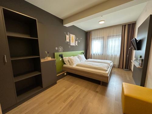 a bedroom with a bed and a tv in it at JUFA Hotel Graz Süd - Self Check-in in Graz