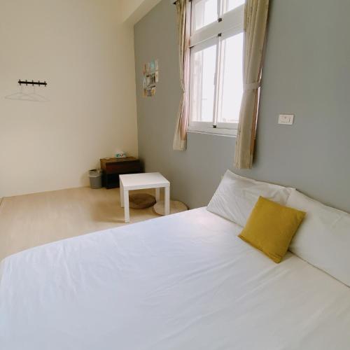 a bedroom with a white bed with a yellow pillow at 綠島夏御 微熱海岸 in Green Island