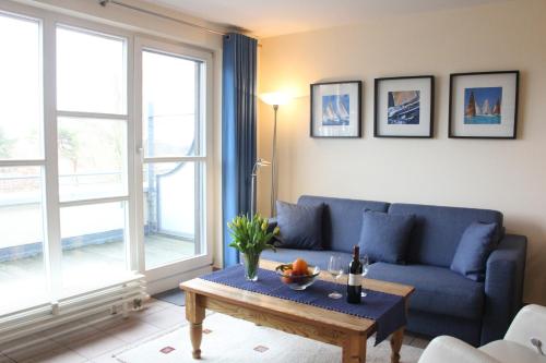 a living room with a blue couch and a table at Ostseeresidenz - Whg 24 in Groß Kirr