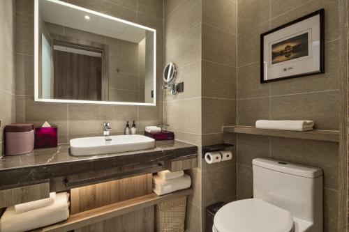 a bathroom with a sink and a toilet and a mirror at Mercure Xi'an Daming Palace in Xi'an