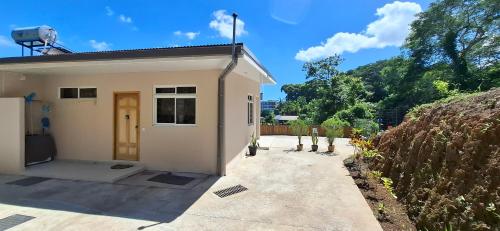 a small white house with a driveway at Fare KnT in Faaa