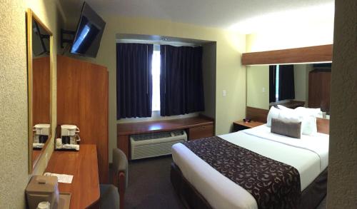 a hotel room with a bed and a desk at Microtel Inn & Suites Beckley East in Beckley
