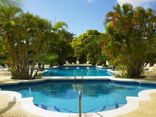a swimming pool with palm trees in a resort at Royal Westmoreland Benjoli Breeze, Palm Ridge 10 by Island Villas in Saint James