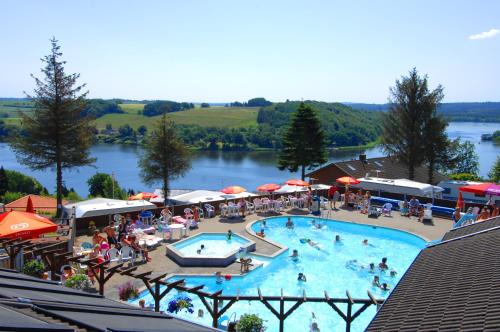 a large swimming pool with people sitting around it at Terrassen Camping & Cottages in Silkeborg