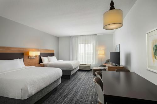 a hotel room with two beds and a tv at TownePlace Suites by Marriott Ames in Ames