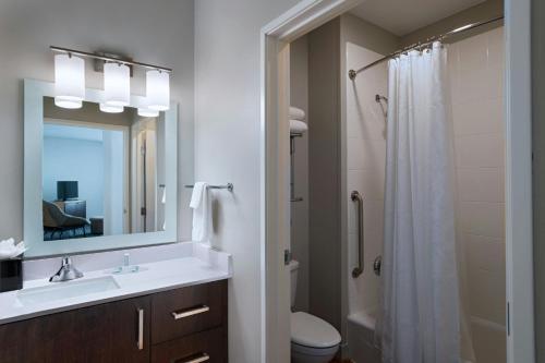 a bathroom with a sink and a toilet and a mirror at TownePlace Suites by Marriott Ames in Ames
