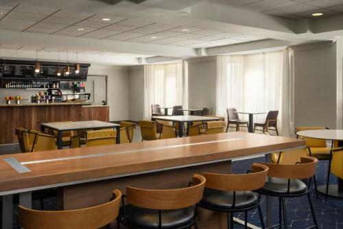 a restaurant with tables and chairs and a bar at Courtyard by Marriott Myrtle Beach Barefoot Landing in Myrtle Beach