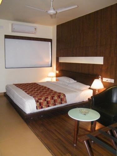 Un dormitorio con una cama y una pantalla grande. en Hotel Skylark, en Dhanbād