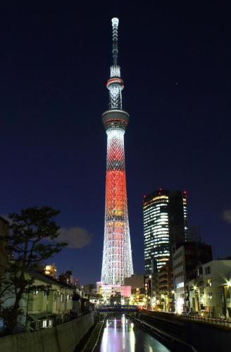 a tall tower lit up in red and white at night at Newly Built 3-Story House in the Heart of Tokyo-Easy Access to Airports,Skytree in Tokyo