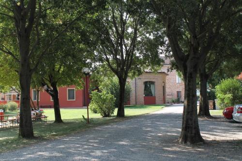 a group of trees in front of a building at Agriturismo Battibue in Fiorenzuola dʼArda