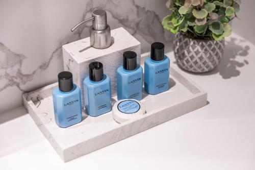 four bottles ofodorizers on a shelf with a vase at Address Opera Residences Burj Khalifa View in Dubai