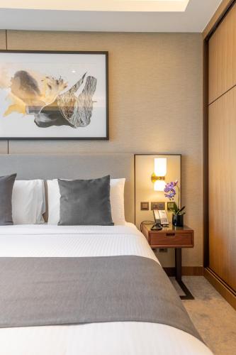 a bedroom with a bed and a desk with a phone at Address Opera Residences Burj Khalifa View in Dubai