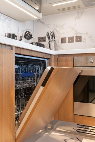 a kitchen with an open dish washer and dryer at Address Opera Residences Burj Khalifa View in Dubai