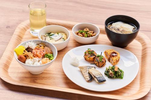 a tray with a plate of food and bowls of food at Hotel Global View Hachinohe in Hachinohe