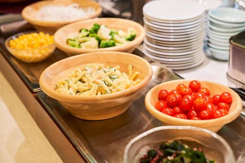 a buffet with bowls of food on a table at Hotel Global View Hachinohe in Hachinohe