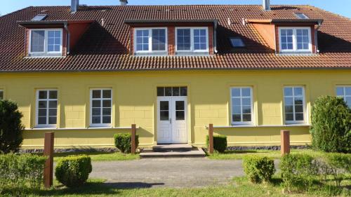 een geel huis met een rood dak bij Parterre B Mitte in Gingst