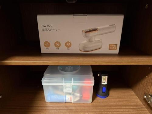 a box and a plastic container on a shelf at 桜Home in Tokyo