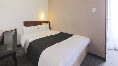 a bedroom with a large bed in a room at Hotel Yamagata Hills Ekimae Odori in Yamagata