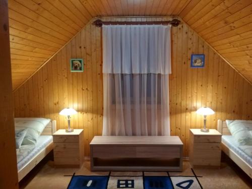 a room with two beds and a window with two lamps at Apartman Daniel in Balatonfőkajár