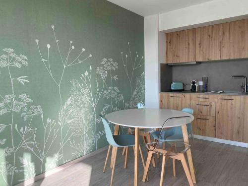 une salle à manger avec une table et des chaises dans une cuisine dans l'établissement Le studio du lac Saint-Point, à Malbuisson