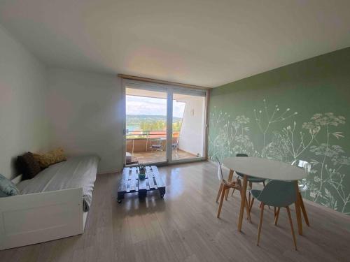 une chambre avec un lit et une table avec des chaises dans l'établissement Le studio du lac Saint-Point, à Malbuisson