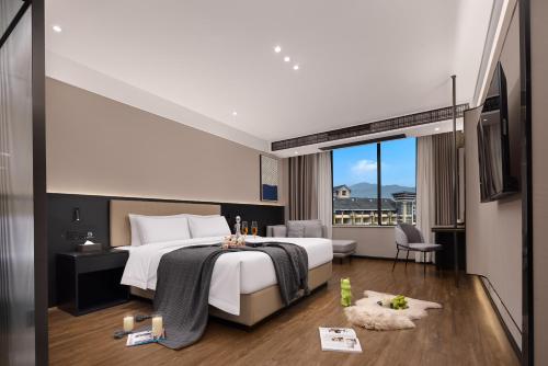 Una habitación de hotel con una cama y una ventana grande. en m designer hotel, en Dujiangyan