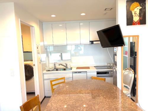 a kitchen with a table with chairs and a television at Tokyo Art House in Tokyo