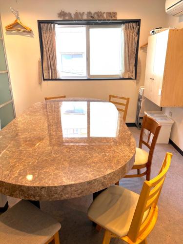 a kitchen with a large marble table and chairs at Tokyo Art House in Tokyo