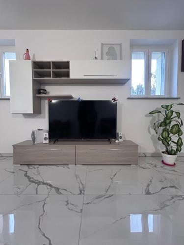 a living room with a flat screen tv on a marble floor at Il Verde in Saluzzo