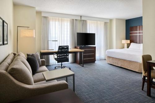 a hotel room with a couch and a bed at Residence Inn Charlotte Uptown in Charlotte