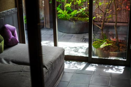 a room with a bed and a patio with plants at GOZAN HOTEL & SERVICED APARTMENT Higashiyama Sanjo in Kyoto