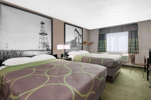 a hotel room with two beds and a tower at Super 8 by Wyndham Bedford DFW Airport West in Bedford