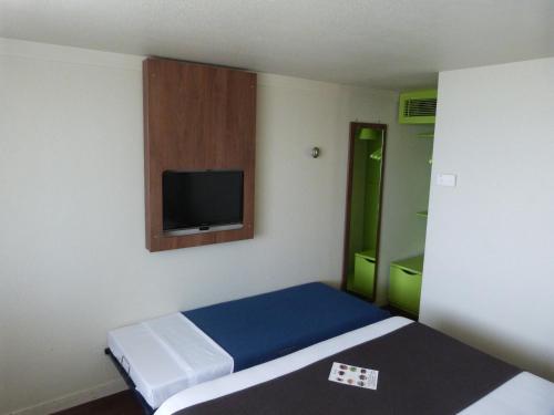 シャルトルにあるCampanile Chartresのベッド1台、薄型テレビが備わる小さな客室です。