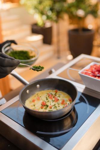 a pan of food sitting on top of a stove at Hotel Spitaler in Appiano sulla Strada del Vino