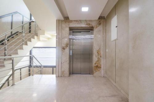 a hallway with a metal door and stairs at Qotel Signature Lavish Rajouri Garden New Delhi in New Delhi
