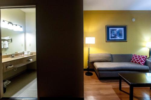 a living room with a couch and a sink at Days Inn & Suites by Wyndham Houston North/Aldine in Houston
