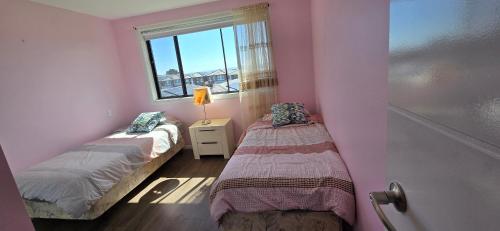 two beds in a small room with a window at New 5x bedroom The Ponds House in Schofields
