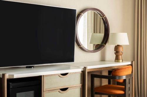 a flat screen tv sitting on a desk with a mirror at Hyatt Regency Greenwich in Greenwich