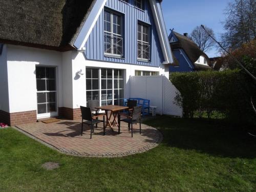 a patio with a table and chairs in front of a house at Kranich in Zingst