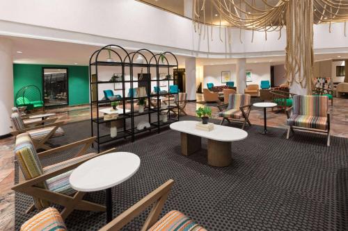 a lobby with tables and chairs in a salon at Wyndham Garden Norfolk Downtown in Norfolk
