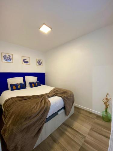 une chambre avec un grand lit avec une tête de lit bleue dans l'établissement T2 en plein cœur du centre ville Coup de cœur garanti, à Marseille