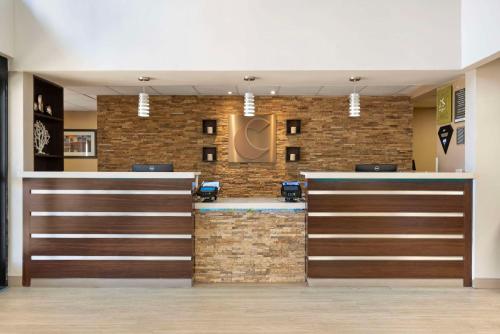 a lobby with a reception desk and a brick wall at Comfort Suites Northside Hospital Gwinnett in Lawrenceville