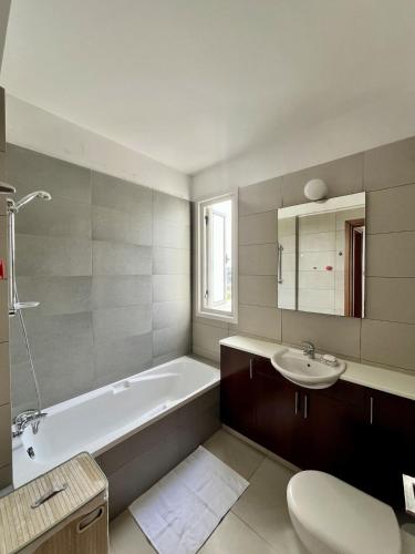 a bathroom with a tub and a sink and a toilet at Luxury Villa Azure in Larnaca